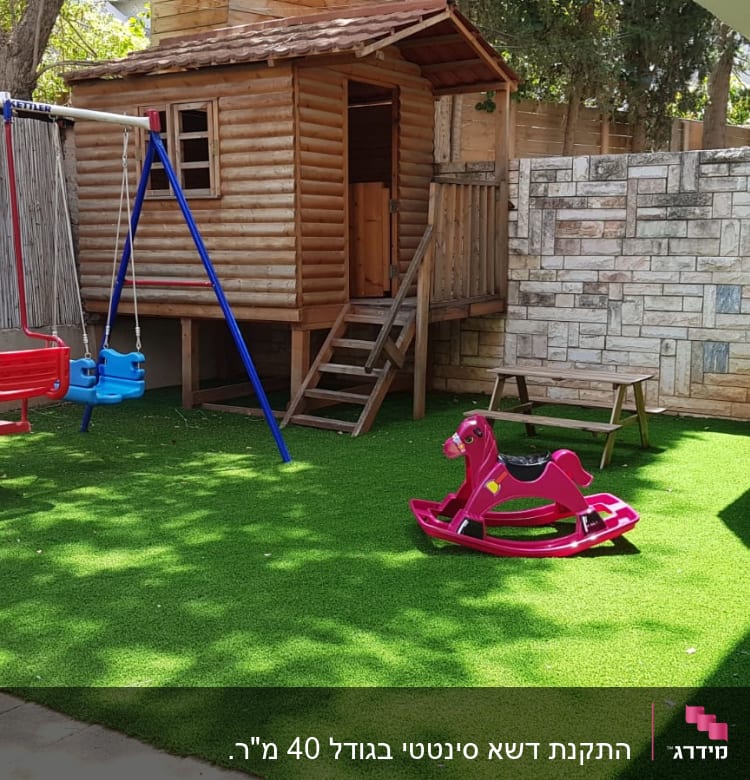 דשא סינתטי בחצר עם נדנדות וצעצועים